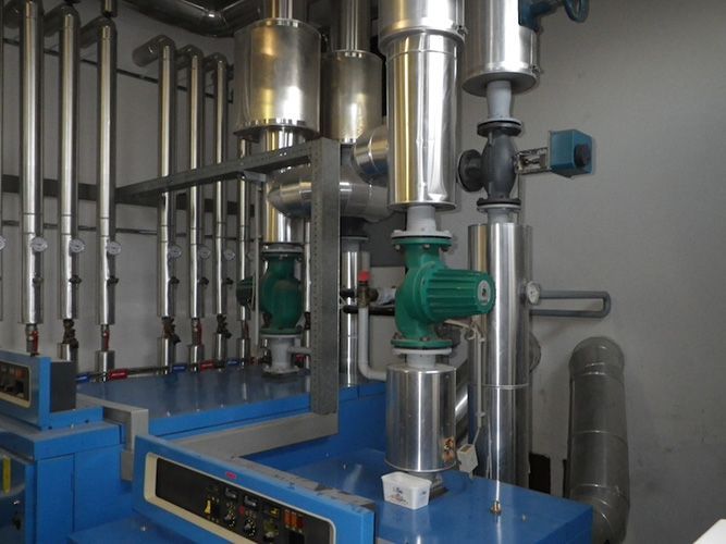 Ein Raum mit vielen Rohren und einer blauen Maschine