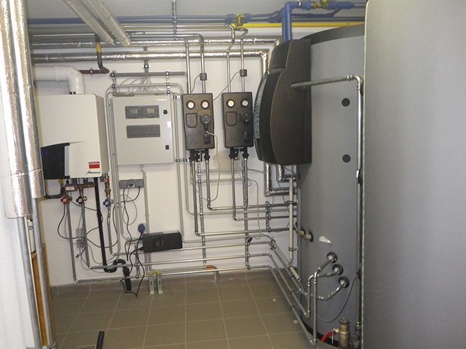 Ein Raum mit vielen Rohren und Kästen an der Wand.