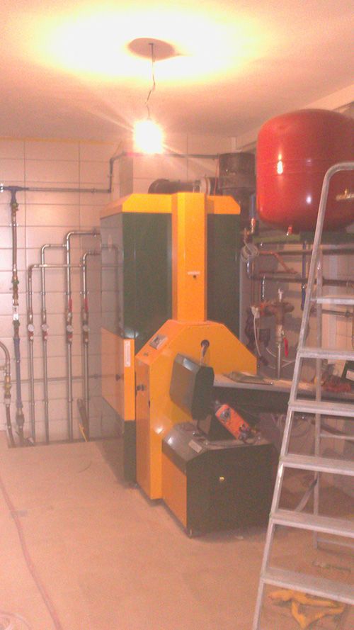 In einem Raum neben einer Leiter steht eine gelb-grüne Maschine.