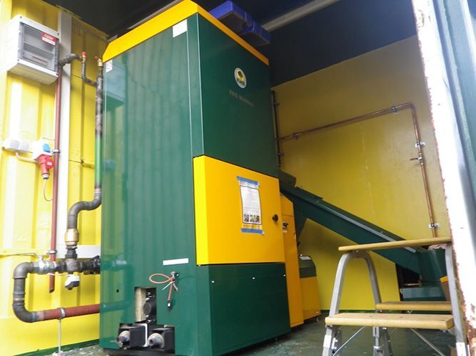 Ein grün-gelber Kessel steht in einem gelben Raum