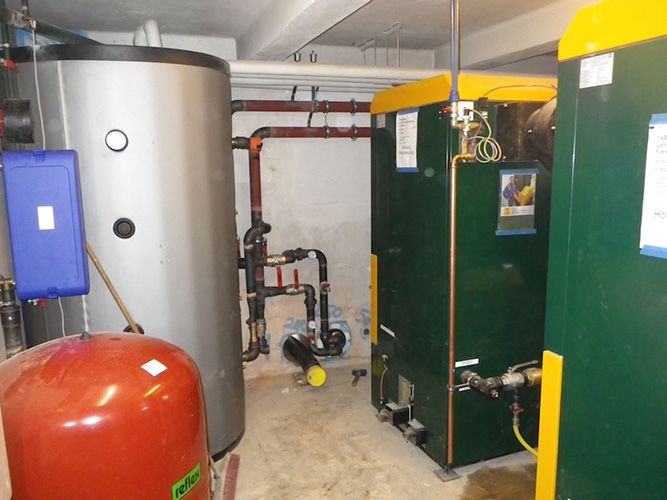 Ein Raum mit zwei grünen Kesseln und einem roten Tank