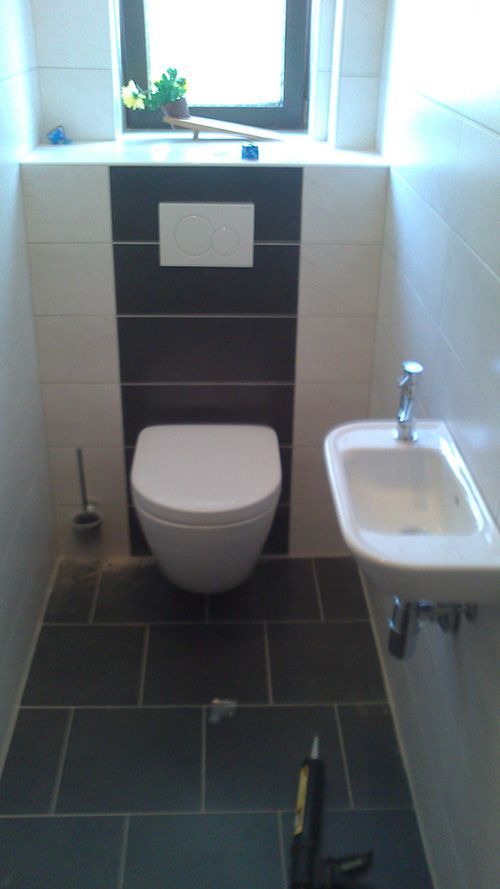 Ein Badezimmer mit Toilette, Waschbecken und Fenster.