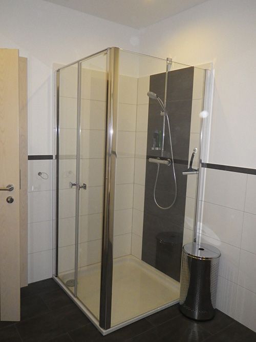 Ein Badezimmer mit Dusche und Mülleimer