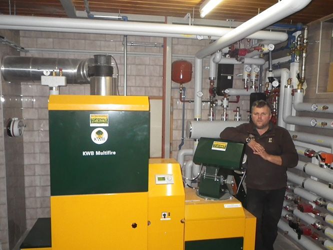 Ein Mann steht vor einer grün-gelben Maschine mit der Aufschrift „io“