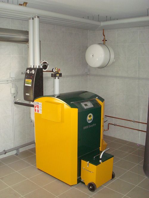 Ein gelber und grüner Heizkessel steht in einem Raum