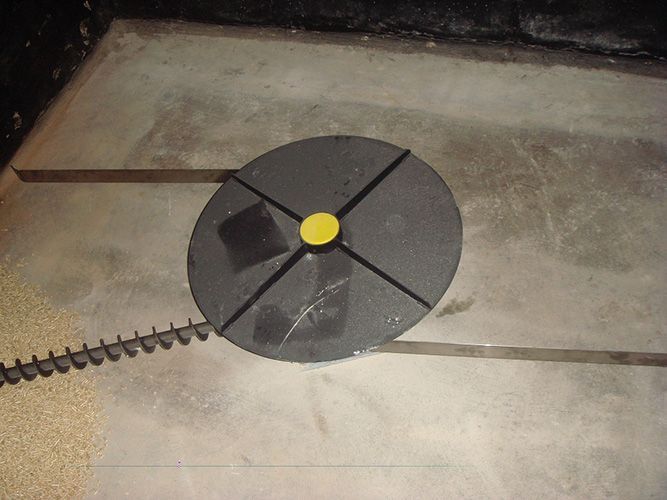 Eine schwarze Scheibe mit einer gelben Mitte liegt auf einem Betonboden