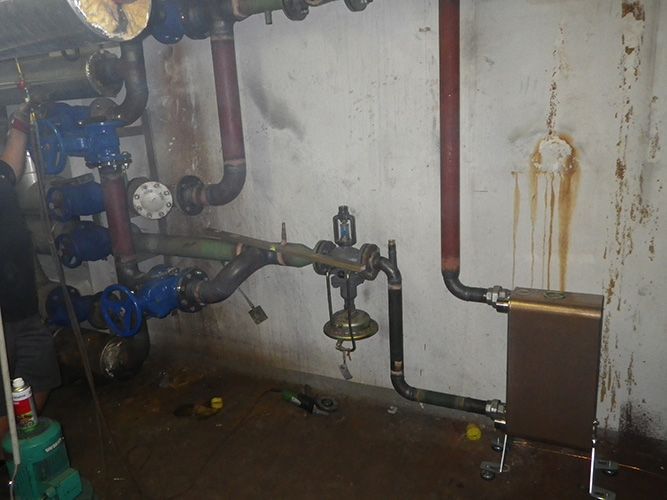 Ein Raum mit vielen Rohren und Ventilen an der Wand.