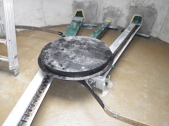 In einem Raum steht eine Maschine, im Hintergrund ist eine Leiter zu sehen.