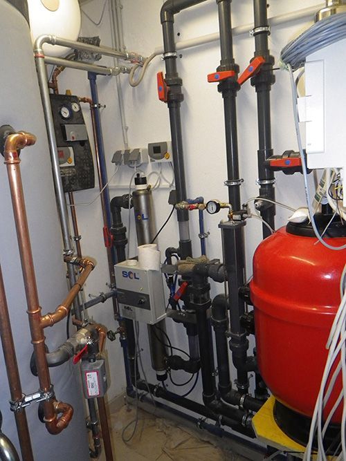 Ein Raum mit vielen Rohren und einem roten Tank