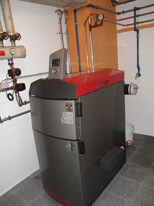 Ein großer grau-roter Kessel mit einer digitalen Anzeige steht in einem Raum