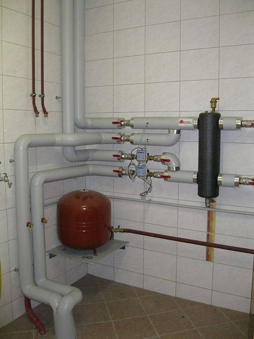 Ein Raum mit vielen Rohren und einem roten Tank