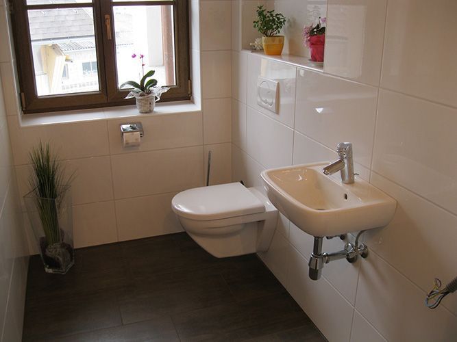 Ein Badezimmer mit Toilette, Waschbecken und Fenster