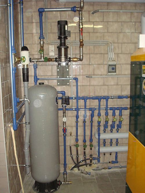 Ein Raum mit vielen Rohren und einem großen Tank