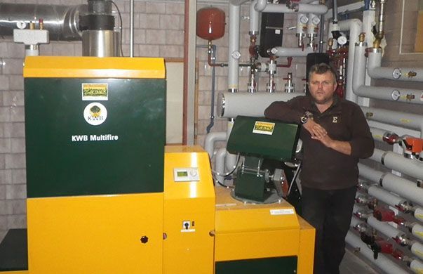Ein Mann steht vor einer grün-gelben Maschine, auf der „Ewi“ steht