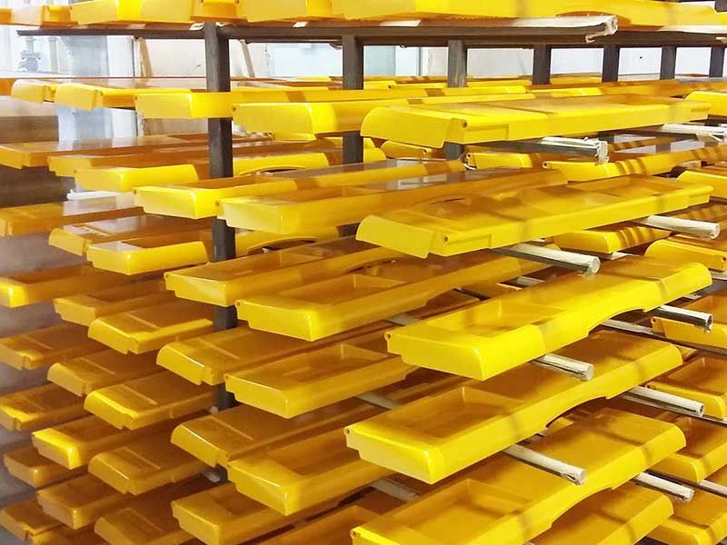 Gelbe rechteckige Wachsformen, die auf Gestellen gestapelt sind.