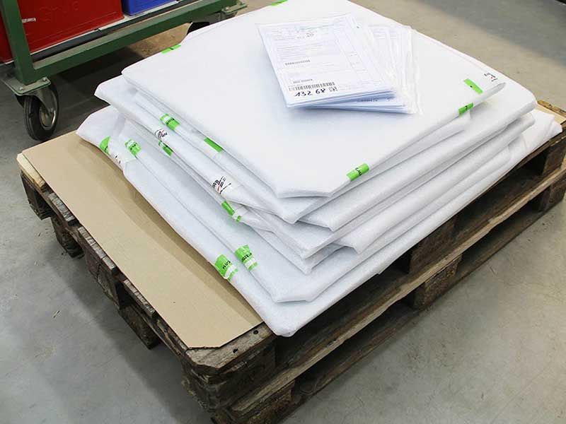 Auf einer Holzpalette sind weiße Stoffbahnen gestapelt