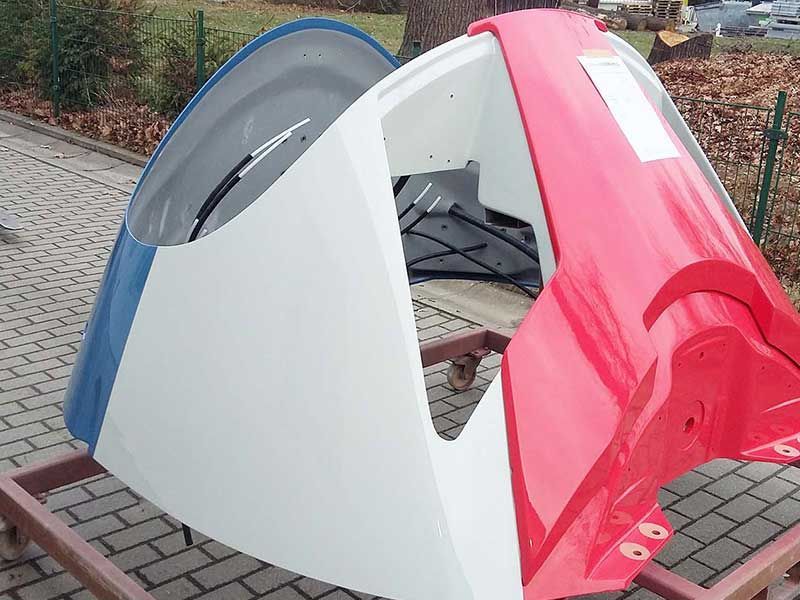 Blau, weiß und rot lackierte Fahrzeugfront steht im Freien