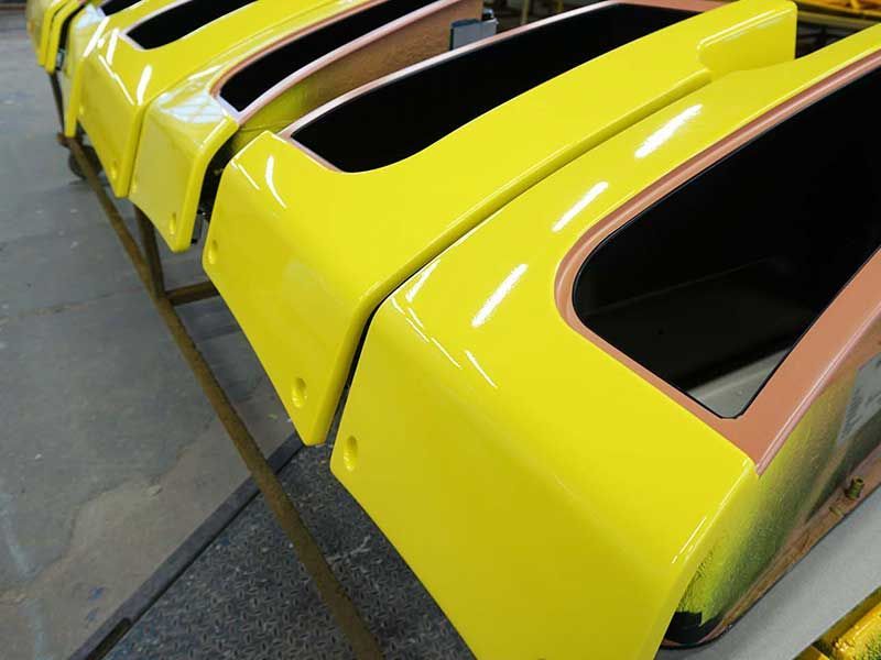 Gelb und schwarz lackierte Fahrzeugteile stehen aufgereiht