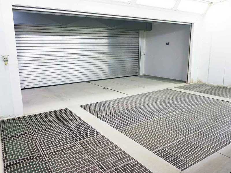 Leere, weiße Lackierkabine mit Metallgitterboden