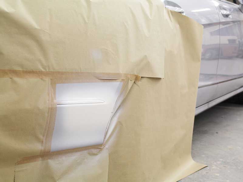 Mit braunem Papier und Klebeband bedeckter Abschnitt der Autotür