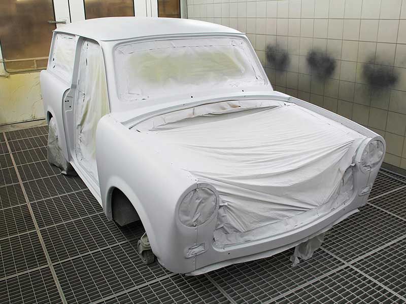 Weißes Auto wird in einer Werkstatt neu lackiert