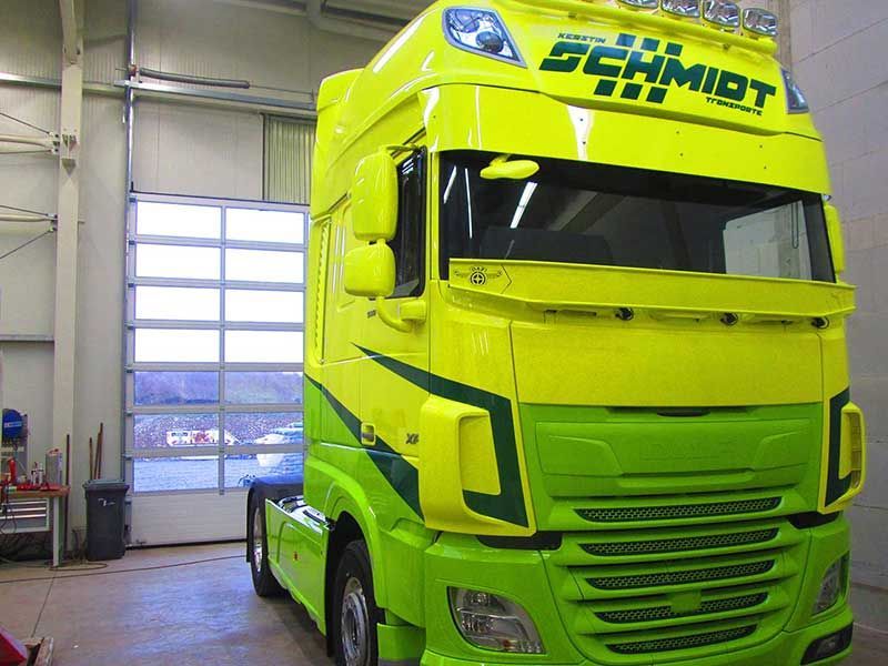 Gelb-grüner Sattelschlepper, der in einer Garage geparkt ist