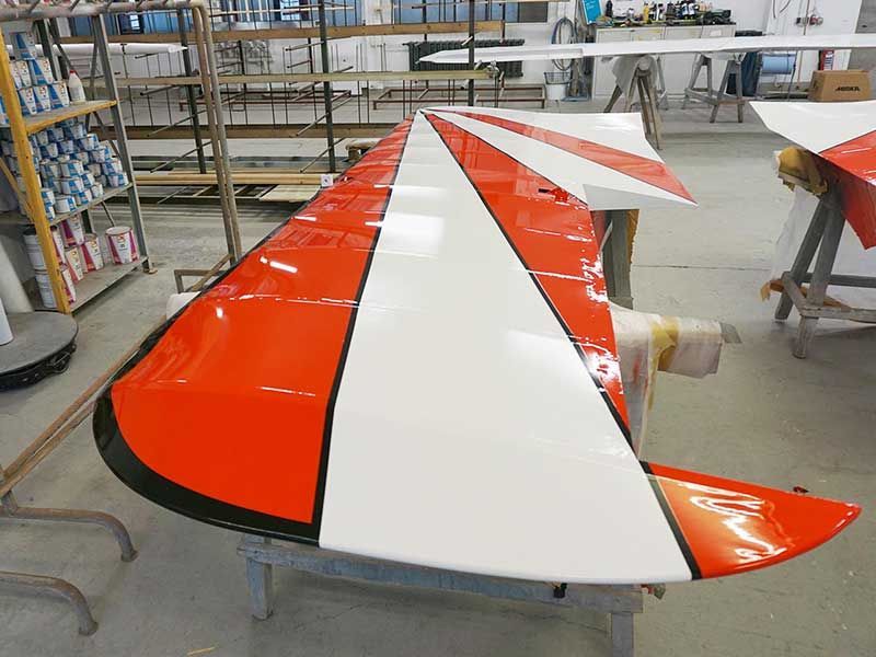 Orange-weißer Flugzeugflügel mit schwarzer Verzierung