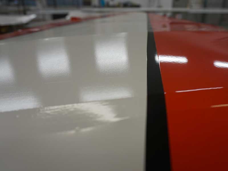 Nahaufnahme eines Flugzeugflügels. Weiße und rote Abschnitte