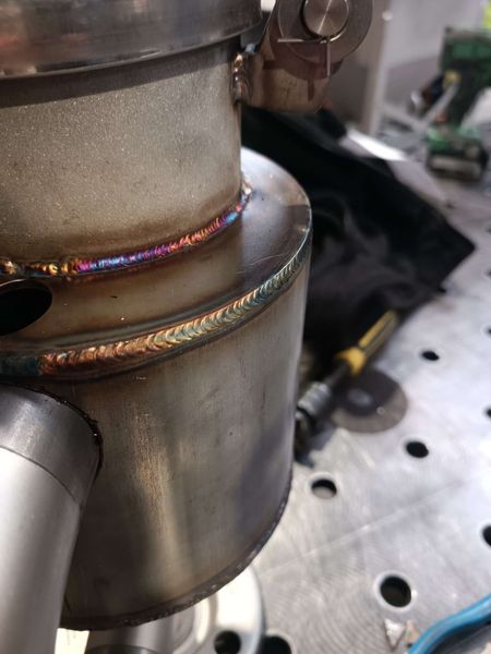 Gros plan sur une soudure TIG circulaire de haute qualité sur un tube en acier inoxydable, montrant une coloration thermique.