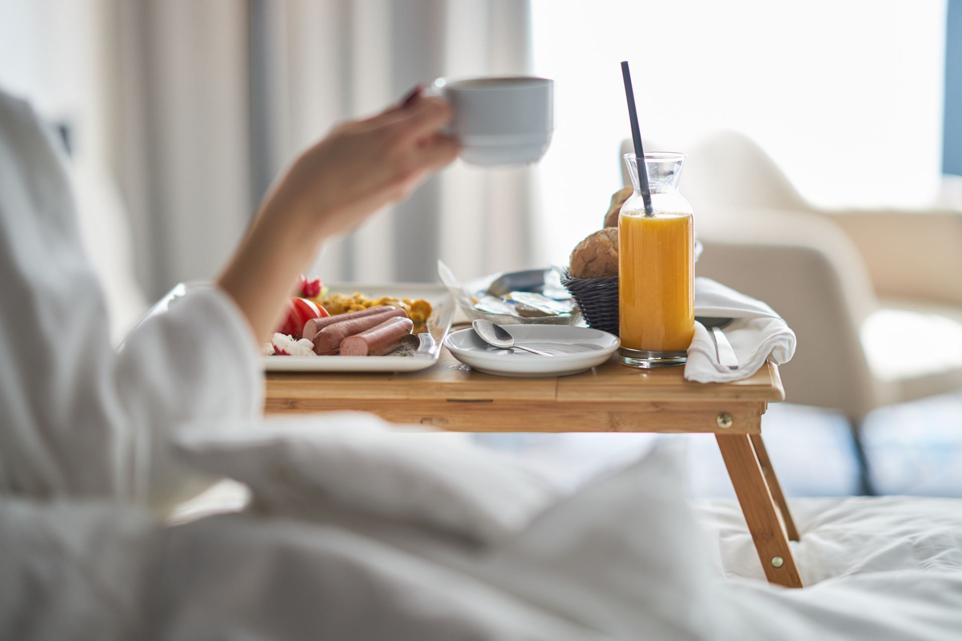 Femme au lit prenant un petit déjeuner