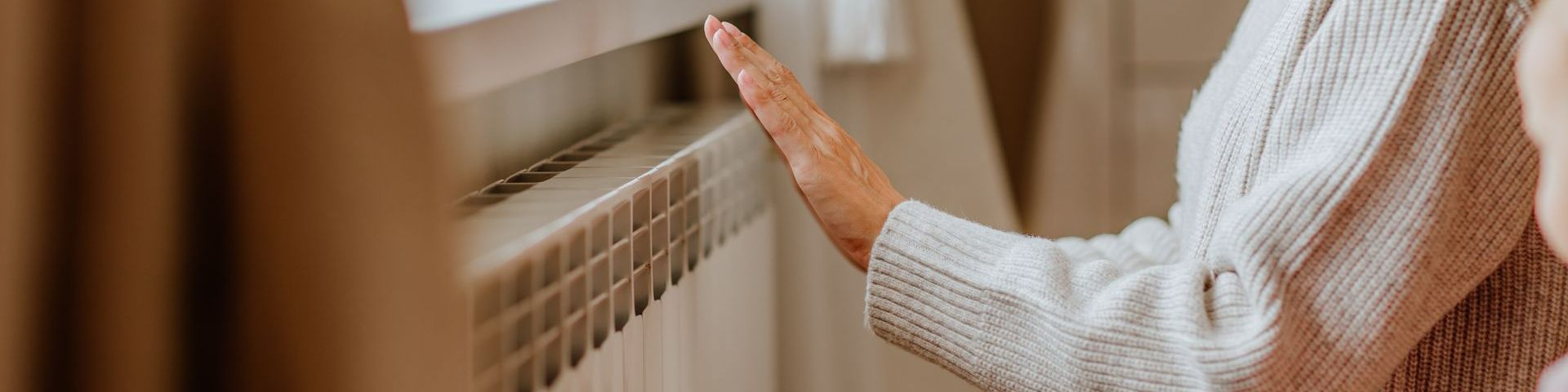 Une main de femme au-dessus d'un radiateur