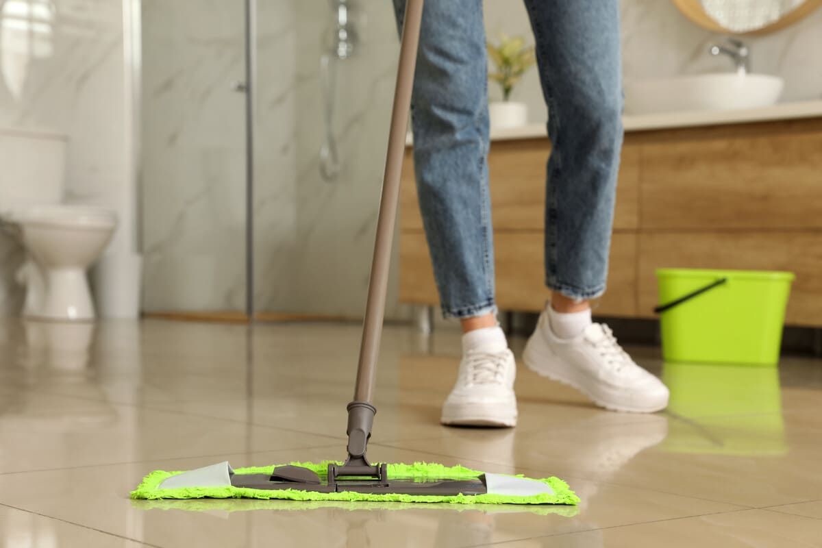 Una persona está fregando el suelo de un baño.