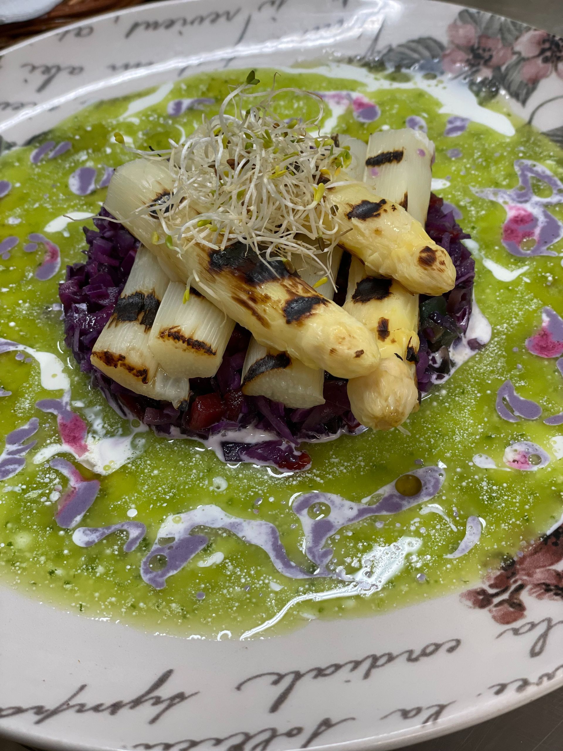 Un plato de comida con espárragos y col morada.