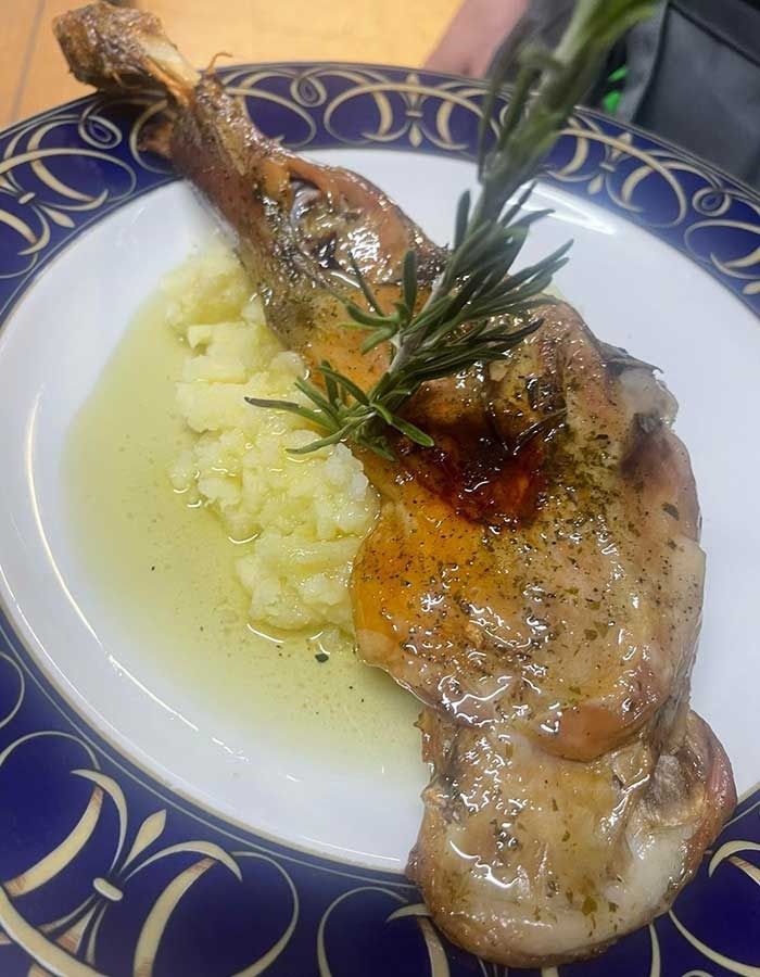 Un plato blanco cubierto con un trozo de carne y puré de papas.
