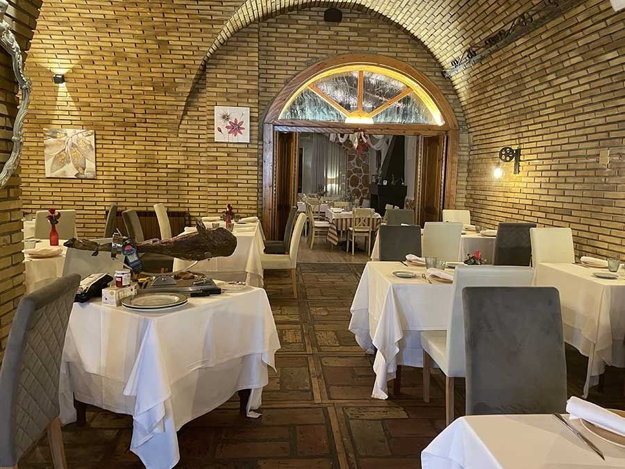 Un restaurante con mesas y sillas y una pared de ladrillos.