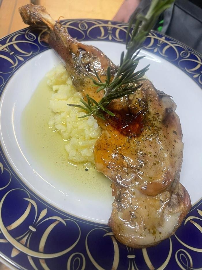 Un plato blanco con un trozo de carne y puré de papas encima.