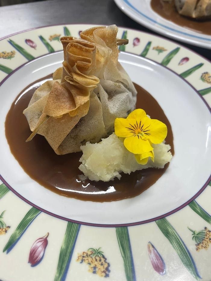 Un plato de comida con una flor encima.