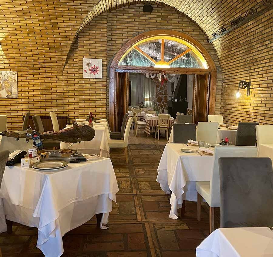 Un restaurante con mesas y sillas y una pared de ladrillos.