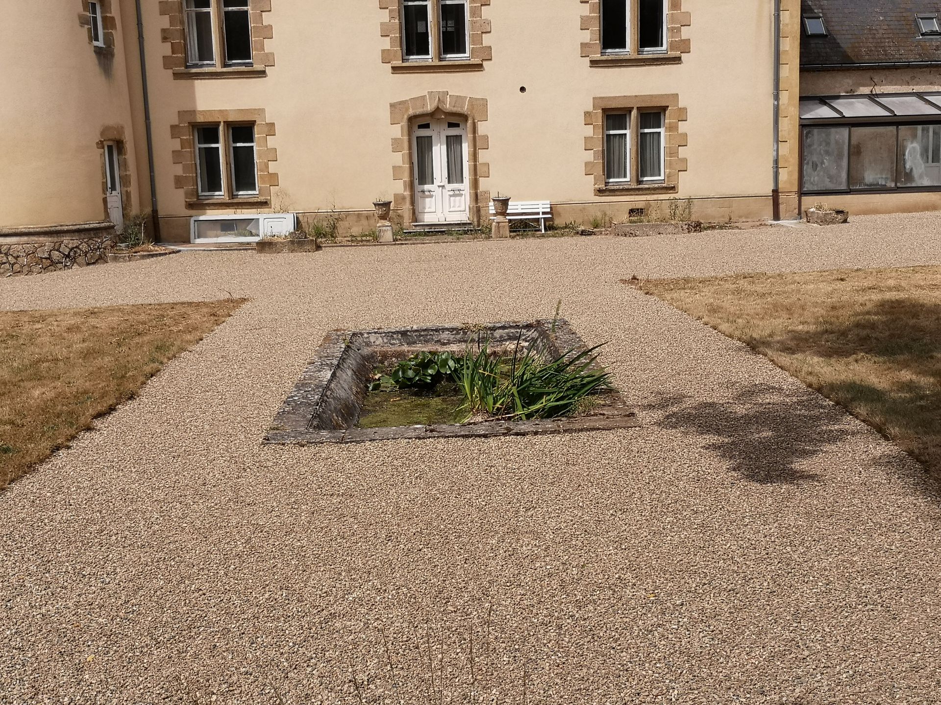 Cours arrière en béton désactivé et graviers