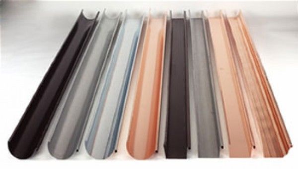 Una fila de canaletas de diferentes colores están alineadas sobre una superficie blanca