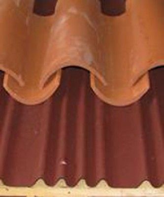 Un primer plano de un techo de tejas rojas con marco de madera.