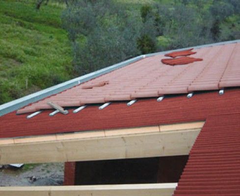 Se está instalando un techo de tejas rojas en un edificio