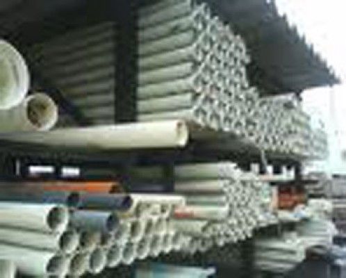 Un montón de tubos de plástico están apilados uno encima del otro en un estante.