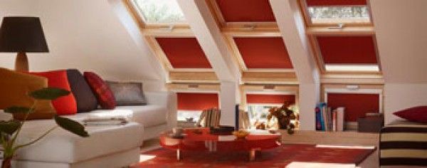 Una sala de estar con muchas ventanas y persianas rojas.