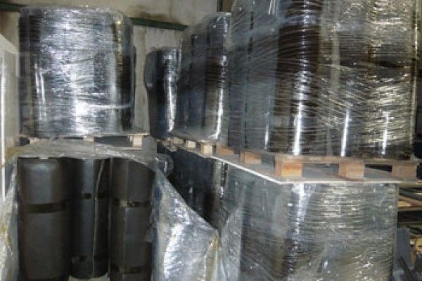 Un almacén lleno de muchos contenedores envueltos en plástico.