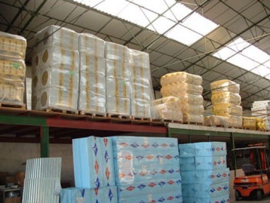 Un almacén lleno de muchas cajas y una carretilla elevadora.