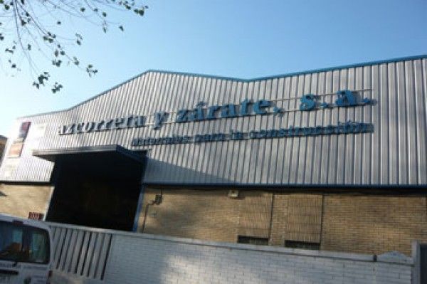 Una camioneta blanca está estacionada frente a un edificio que dice seguridad y zarate sa
