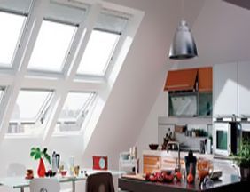 Una cocina con muchas ventanas y una mesa y sillas.