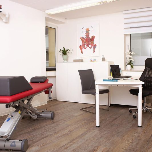 Behandlungsraum mit Tisch und Liege