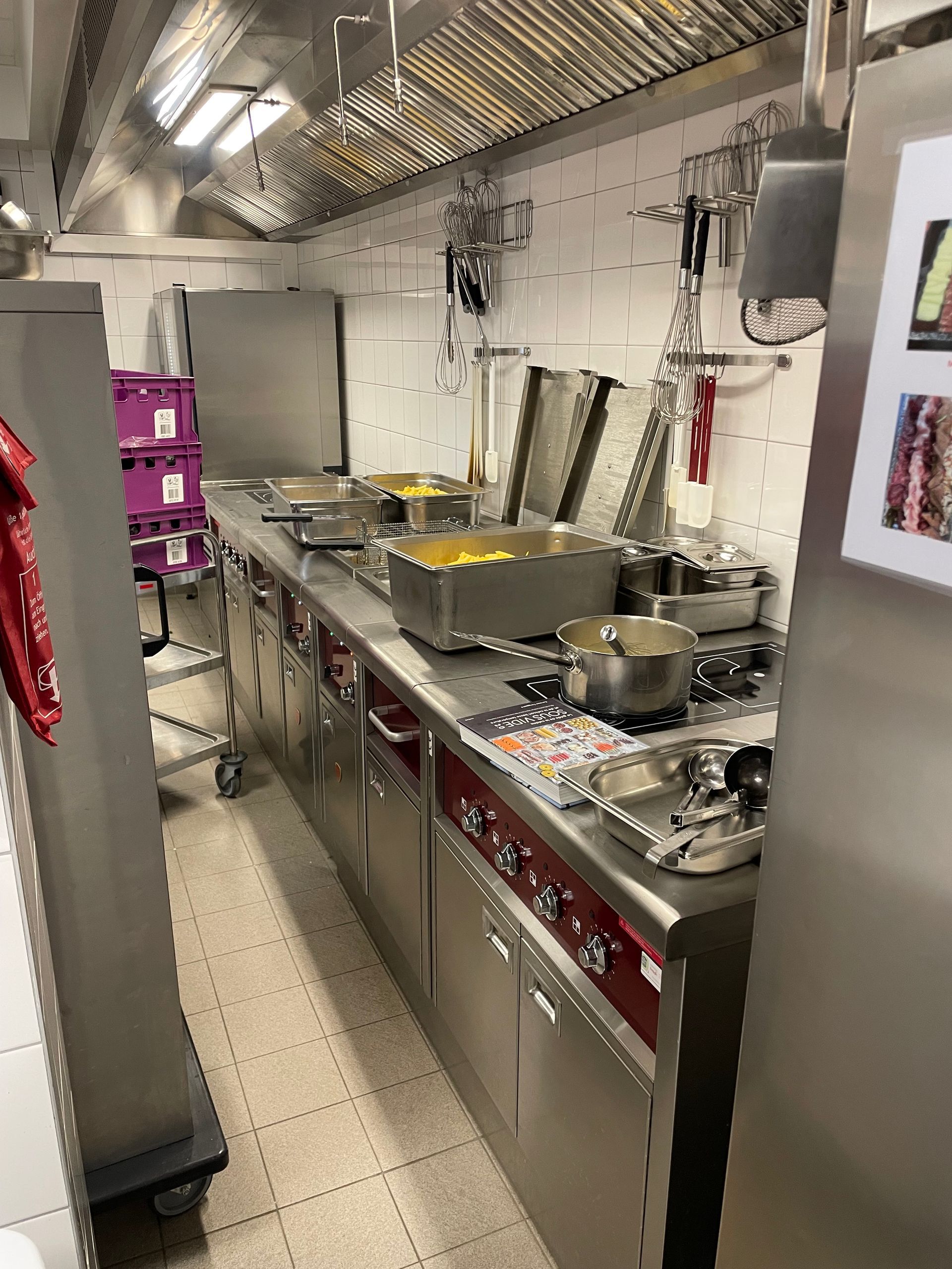 Cuisine professionnelle équipée d'appareils en acier inoxydable, de casseroles et d'aliments.